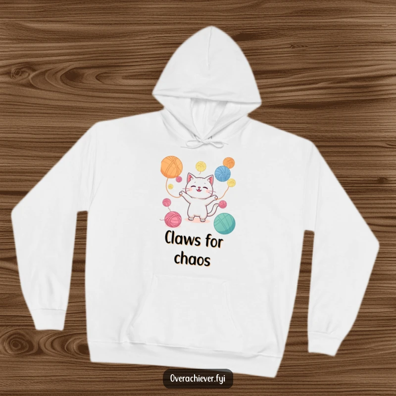 Funny hoodie illustrating a Kawaii cat adorably juggling an excessive amount of colorful yarn balls, offering warmth and humor.